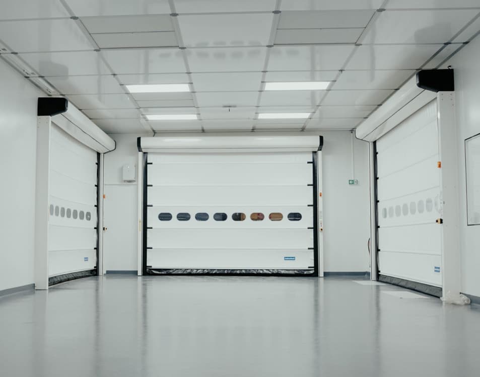 white room with 3 white garage style doors