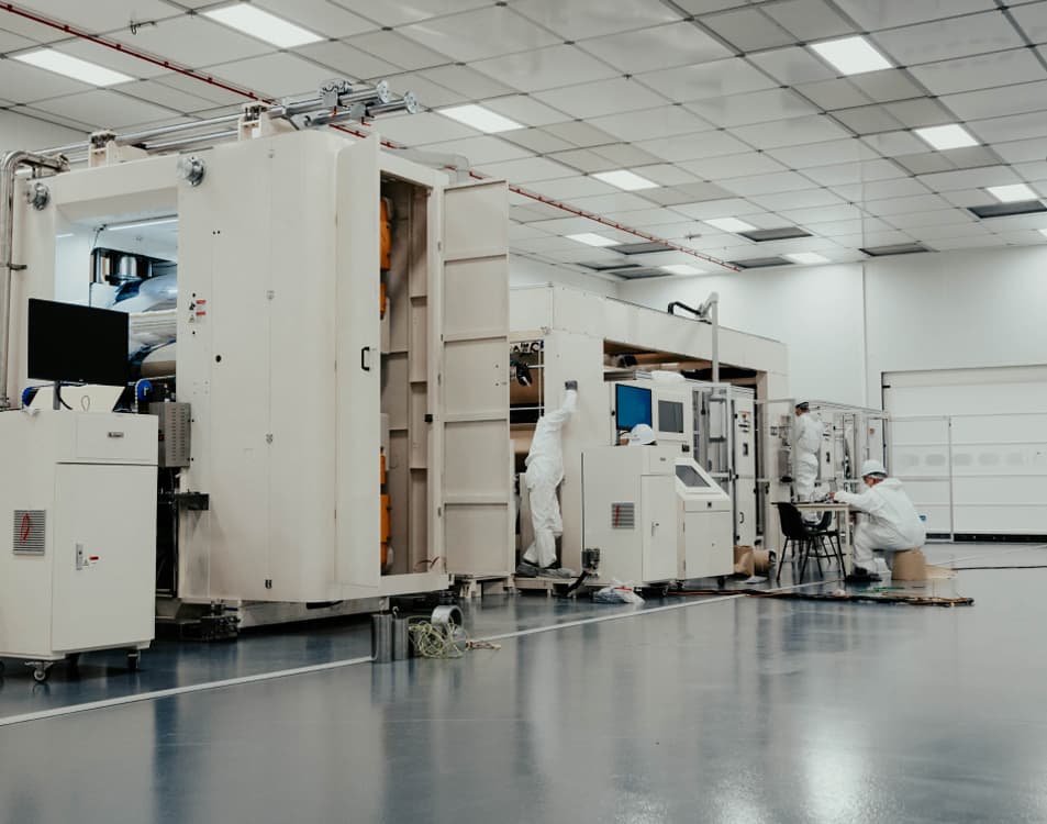 people working on industrial manufacturing equipment